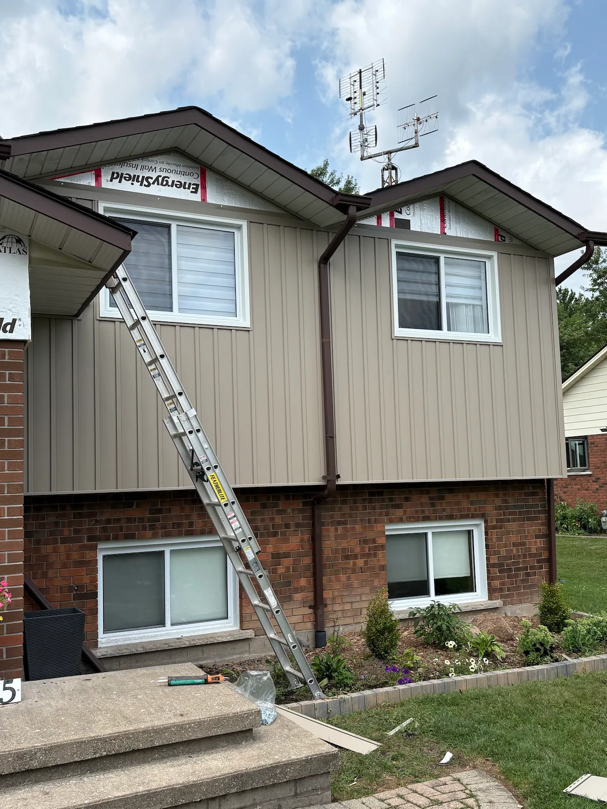 Board-and-batten siding installation in progress over exterior insulation