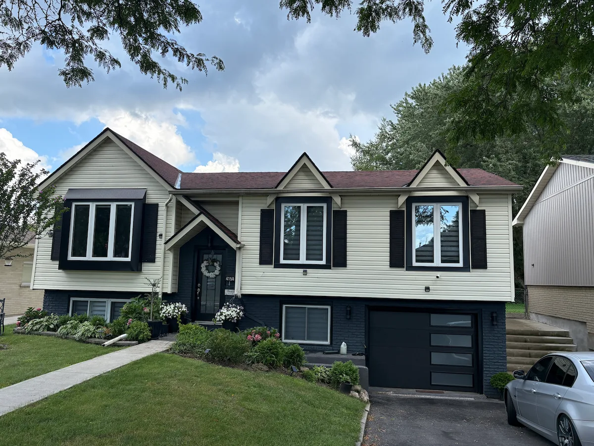 Home exterior with replacement casement windows and black exterior capping installed by Great Northern Home Exteriors