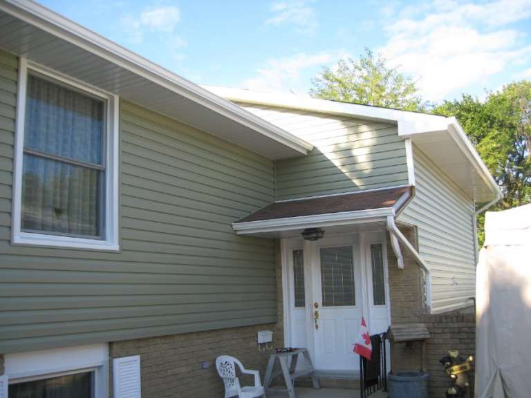 Cypress Green Horizontal Siding With White Eavestrough GNHE Windows