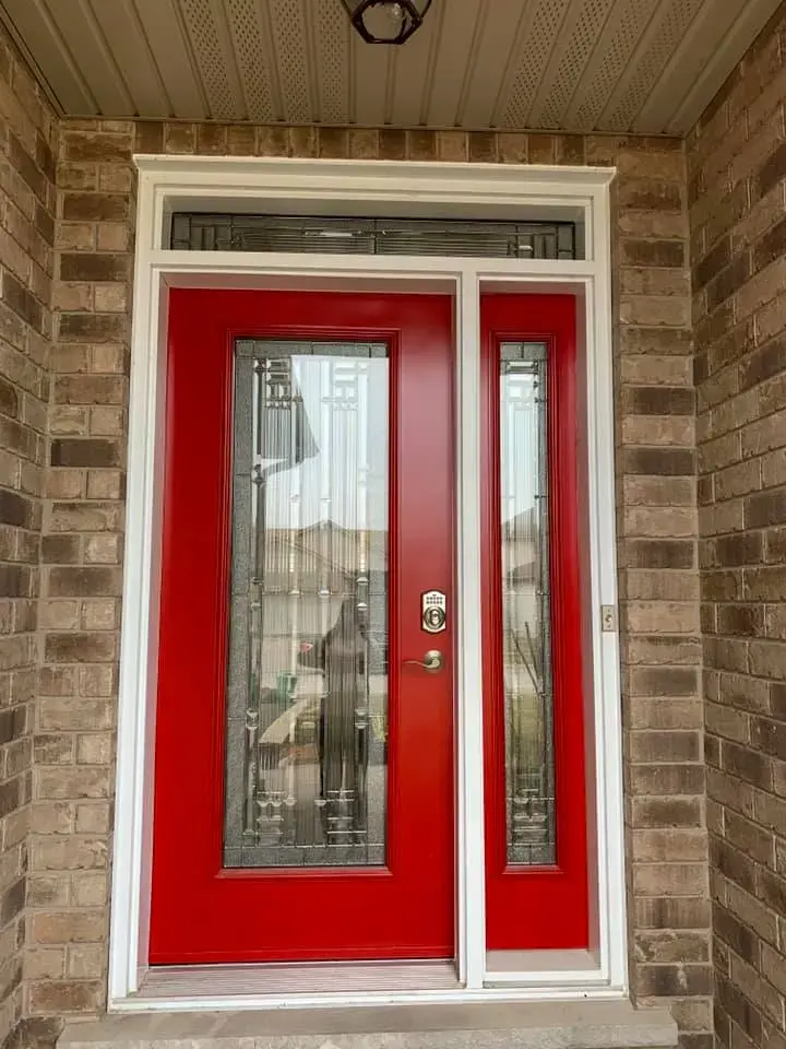 Red entry door with transom providing strong curb appeal on a neutral exterior