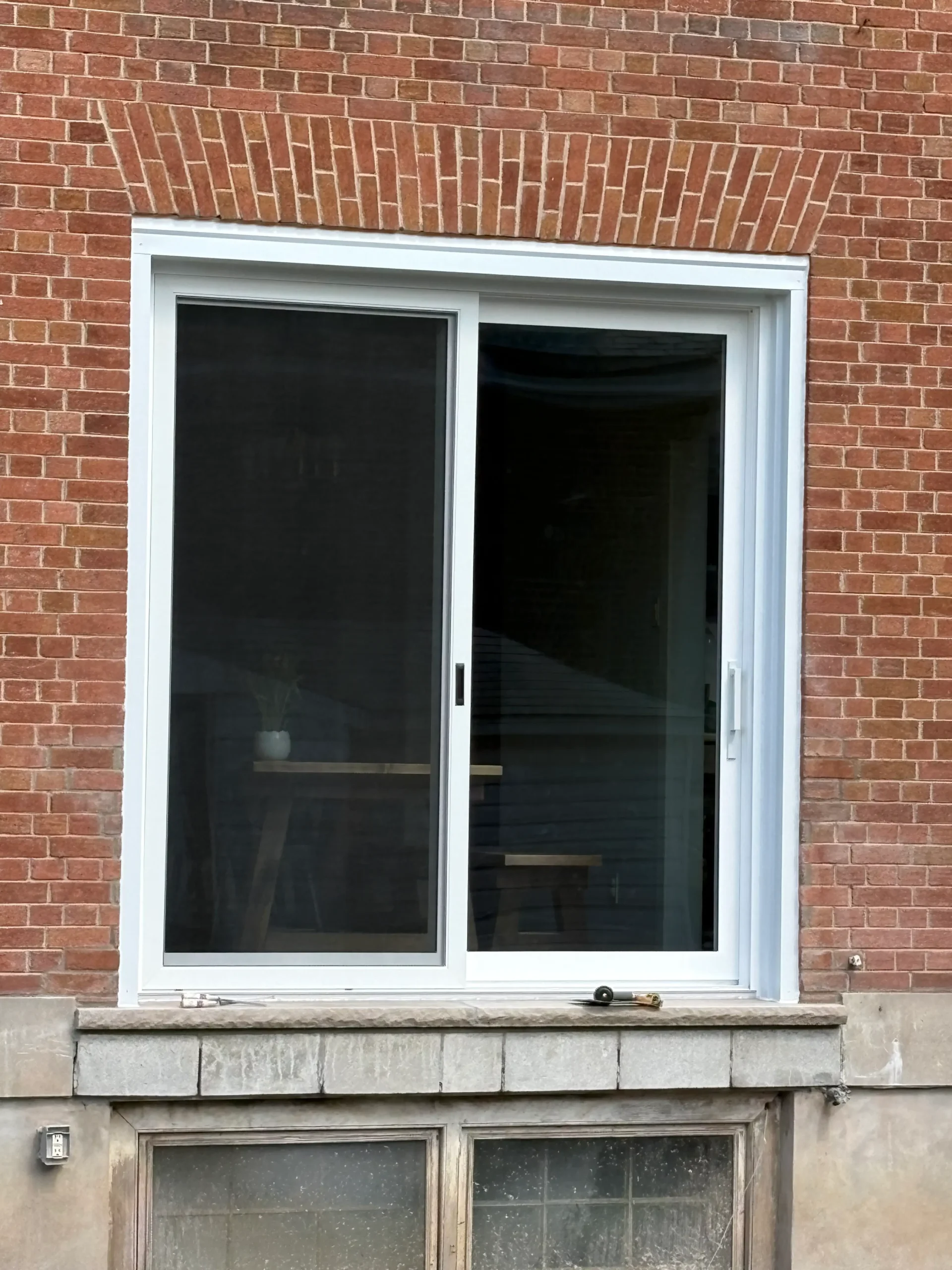 Finished exterior patio door with limestone sill and brickwork