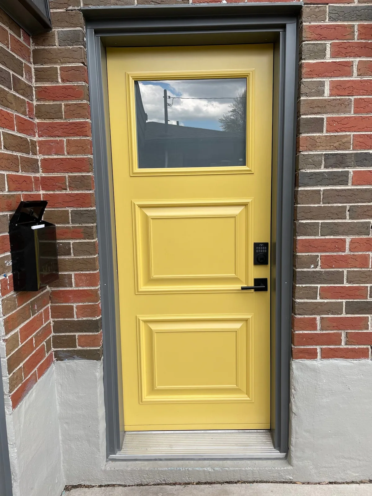 Single entry door with a yellow slab installed by Great Northern Home Exteriors