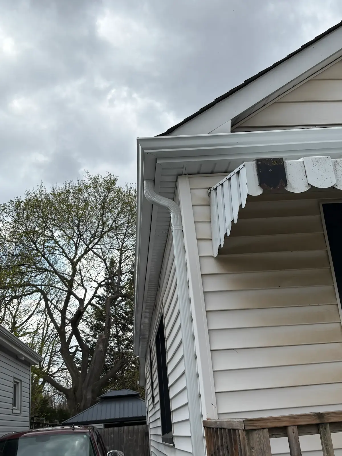 White eavestrough, fascia, soffit and downpipe installed along a finished roof edge