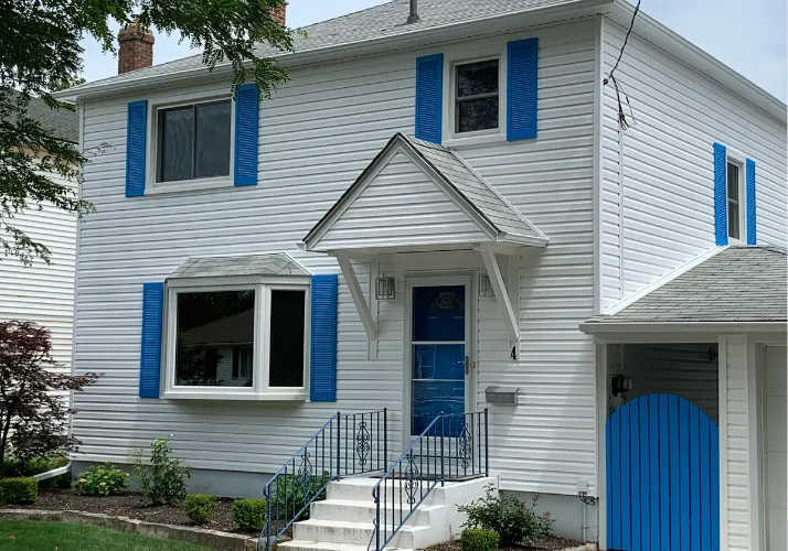 White horizontal vinyl siding with custom blue shutters installed by Great Northern Home Exteriors in St. Catharines.