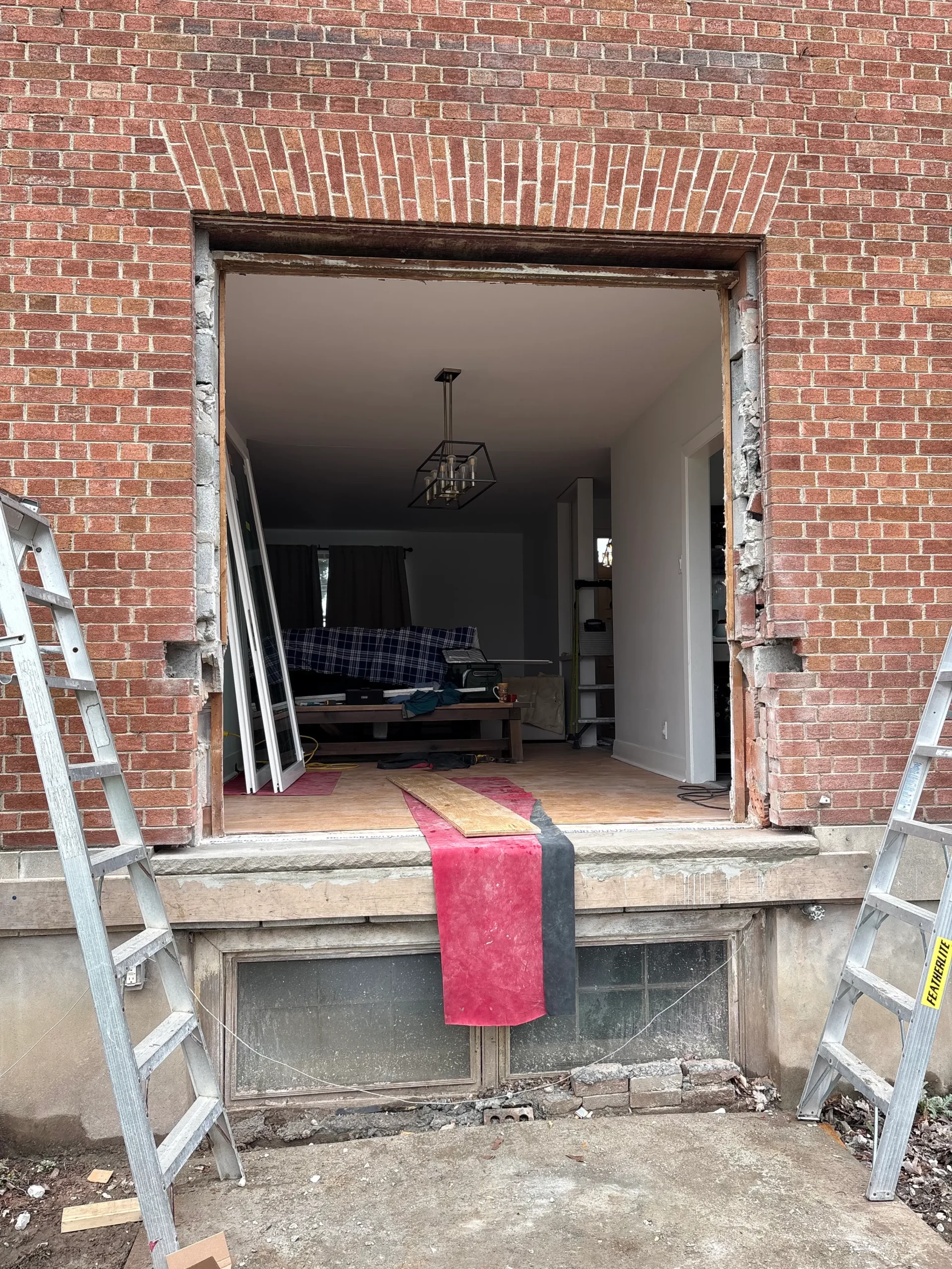 Exterior brick cutout after window removal for patio door