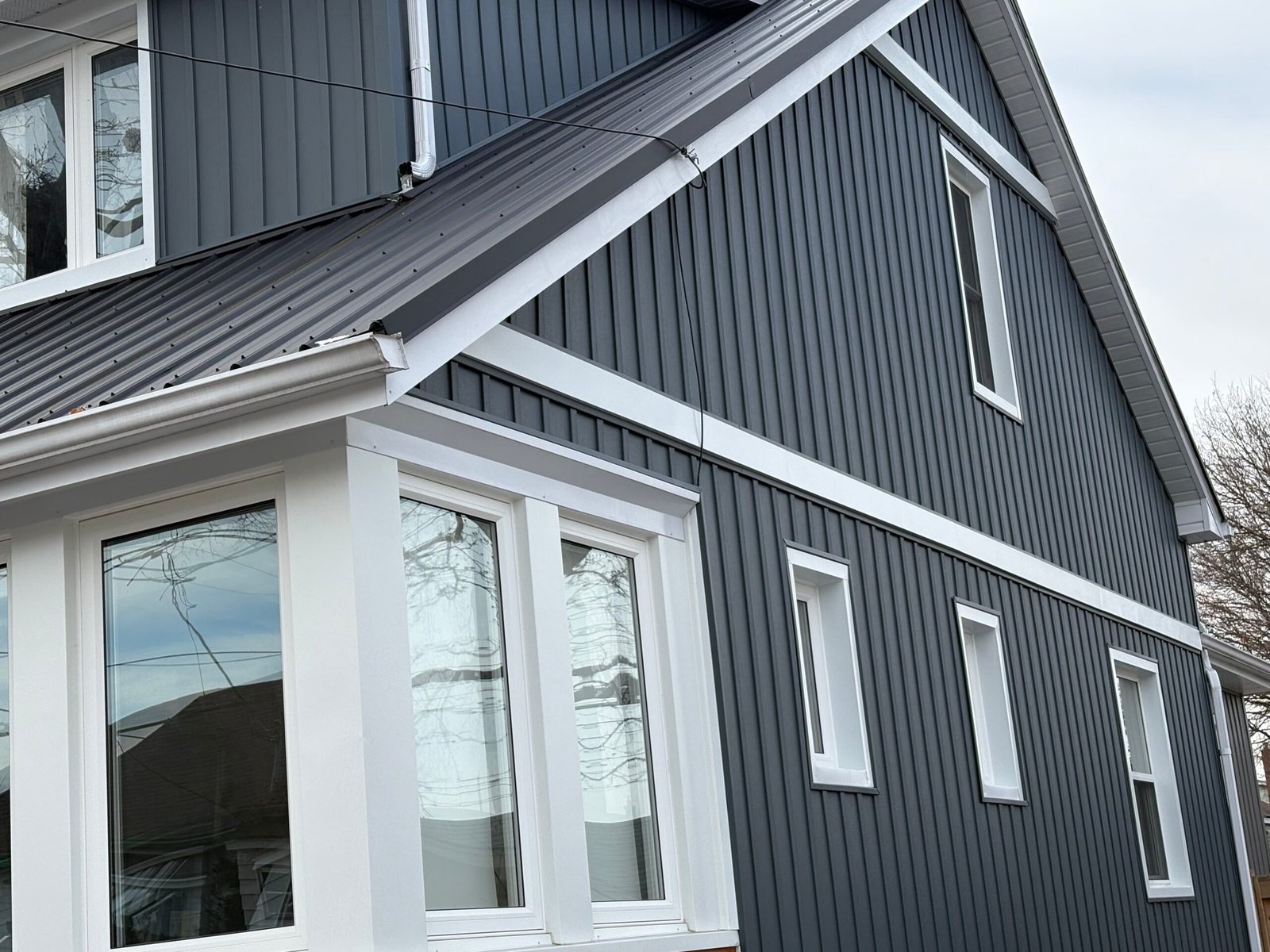 Dark grey board and batten exterior siding installed in St. Catharines