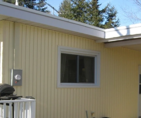 vertical-siding-niagara-falls.webp Vertical vinyl siding installation on a Niagara Falls home with light yellow panels and white trim.
